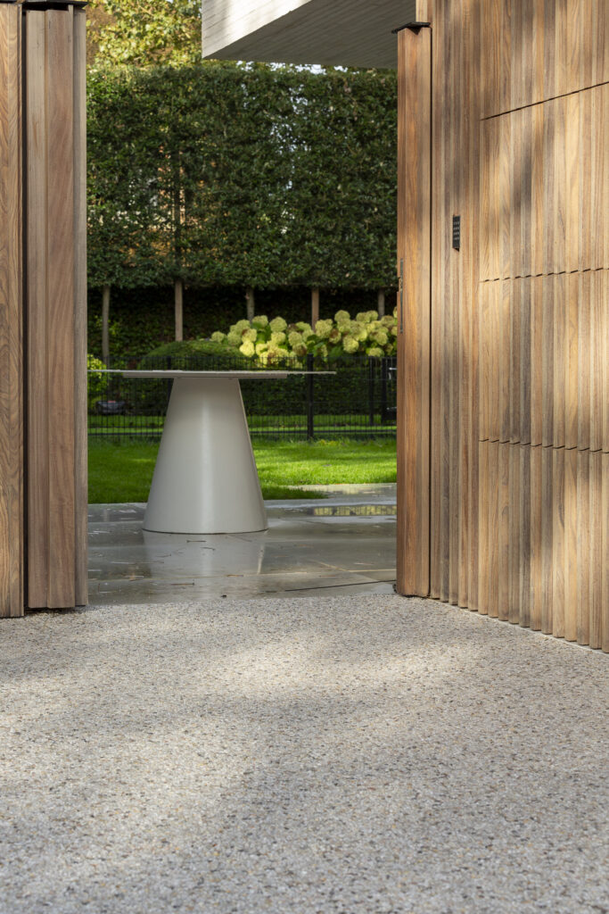 Waterdoorlatende Terradec aangebracht voor de garage-ingang, met op de achtergrond een groene tuin